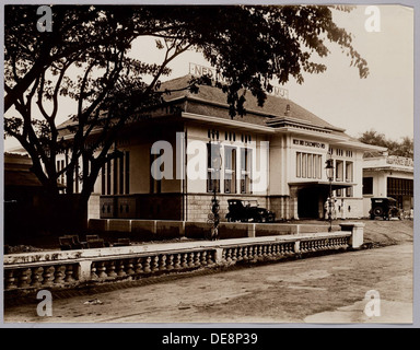 The Bank of Dutch Indies Escompto Company building, constructed in the 1920s-1930s, is a prime example of Dutch commercial architecture. The design combines classical and modernist influences, featuring a grand facade and functional office spaces. This building reflects the economic growth of the period, housing a major financial institution in the Netherlands. Stock Photo