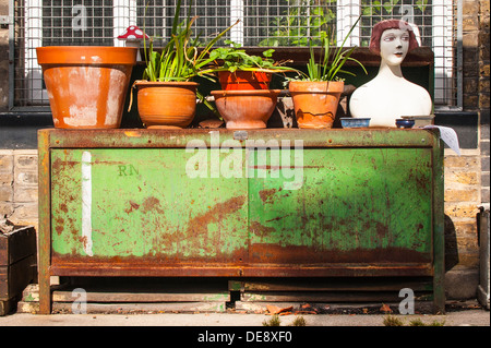 East End London Fish Island Hackney Wick back street scene urban garden pot plants female dummy on rusty metal office cupboard cabinet fun quirky Stock Photo