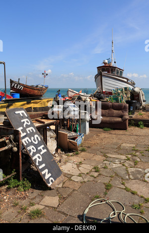 Fishing boats and sign for fresh herrings on a south coast beach seafront in Deal, Kent, England, UK, Britain Stock Photo