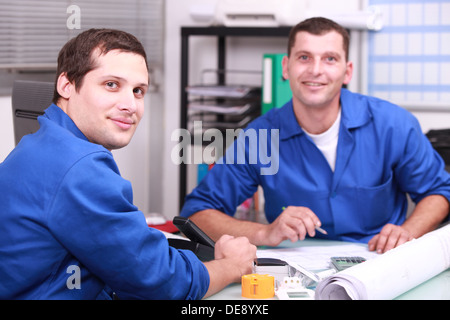 Two manual worker in the office checking stock levels Stock Photo