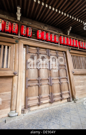 Grand wooden doorway and red lanterns on a traditional Japanese building Stock Photo