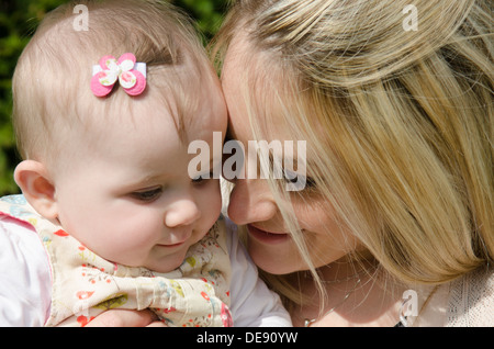 young mother with eight month old baby girl in garden Stock Photo