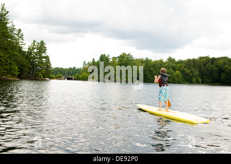 young boy stand up paddle boarding Stock Photo