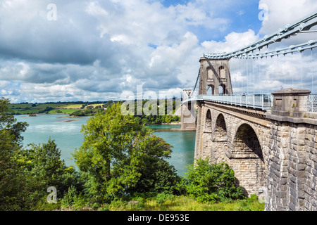 The Menai Suspension Bridge, designed by Thomas Telford, looking across Menai Strait towards the island of Anglesey, Wales, UK Stock Photo