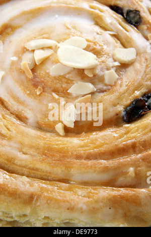 Danish pastry close up with toasted almonds, icing and raisins Stock Photo