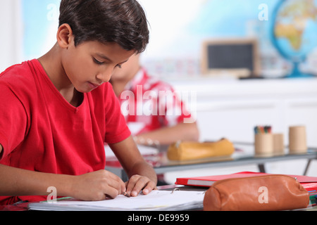 little boy focusing on his work in classroom Stock Photo