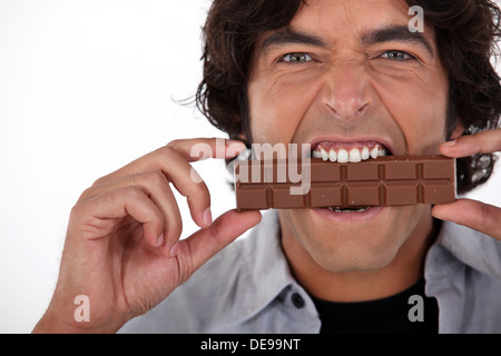 Man playfully eating chocolate Stock Photo