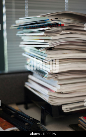 Overflowing inbox with excessive paperwork and magazines piled up Stock Photo