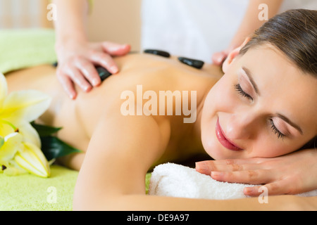 Beautiful woman having a wellness hot stone back massage Stock Photo
