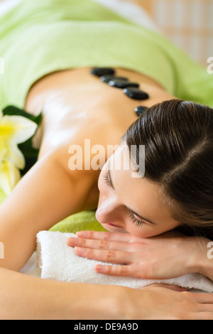 Beautiful woman having a wellness hot stone back massage Stock Photo
