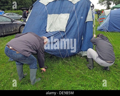 Happy campers erecting a tent at a festival or sporting event (F1 Grand Prix) Stock Photo