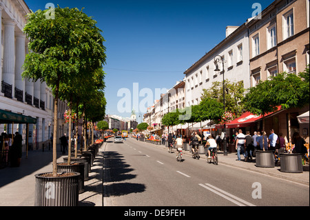 tourists on cycles on street at Nowy Swiat Stock Photo