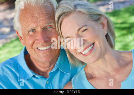 Happy senior man and woman couple sitting together outside in sunshine Stock Photo