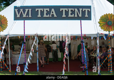 Women's Institute W.I tea tent with a large sign, colourful bunting and people inside at the music festival Camp Bestival Stock Photo