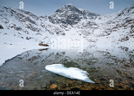 Ice Formations in Llyn Glaslyn and the Snow Capped Peak of Mount Snowdon, Snowdonia National Park, North Wales, UK Stock Photo