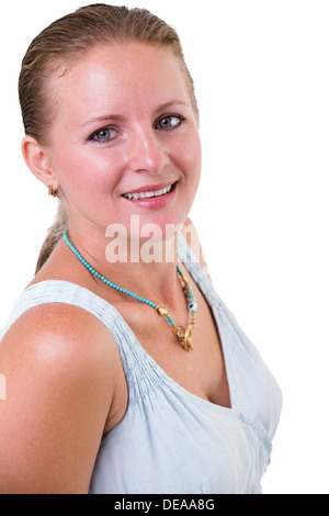 Portrait of a beautiful smiling young woman with her hair neatly tied back standing sideways turning to look at the camera Stock Photo