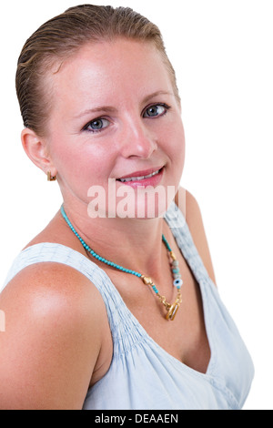 Portrait of a beautiful smiling young woman with her hair neatly tied back standing sideways turning to look at the camera Stock Photo