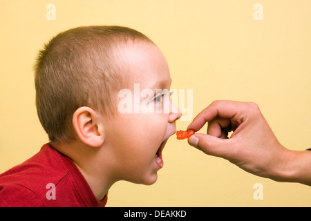 Boy, 2 years, getting a gummy bear Stock Photo