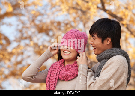 Young Man Covering a Young Woman's Eyes with Hat Stock Photo