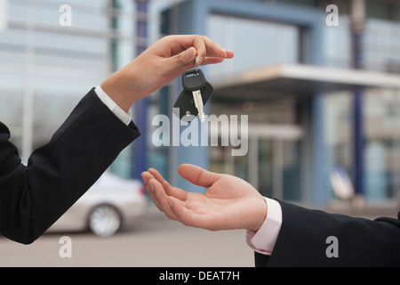 Salesman handing over car keys, close up on hands Stock Photo