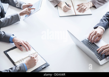 Four business people around a table and during a business meeting, hands only Stock Photo