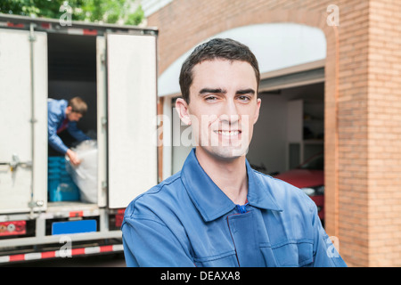 Portrait of smiling mover with moving truck in the background Stock Photo
