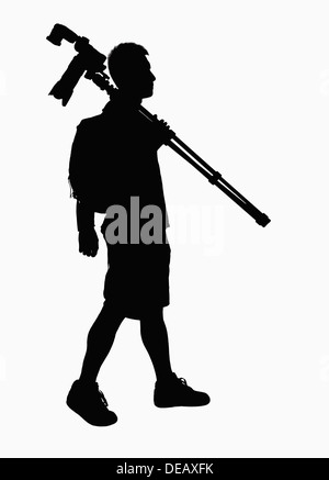 Silhouette of man carrying camera and tripod. Stock Photo