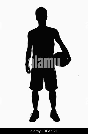 Silhouette of basketball player holding ball. Stock Photo