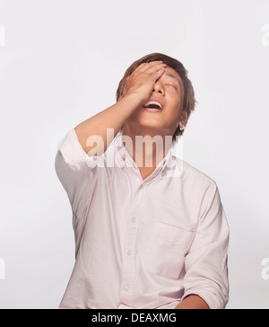 Anxious man with hand over face, studio shot Stock Photo