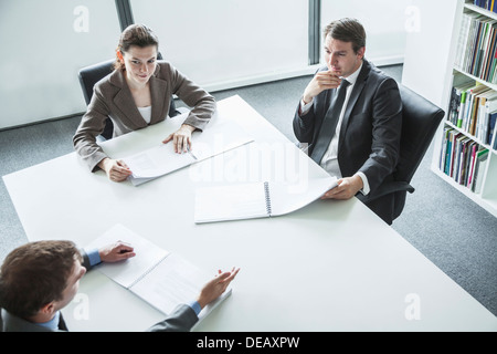 Three business people sitting around a table and having a business meeting, high angle view Stock Photo