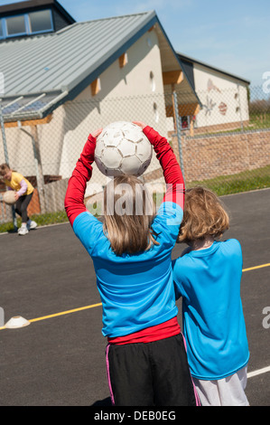 Pre-teen children pupils playing games at breaktime in a primary school, Wales UK Stock Photo