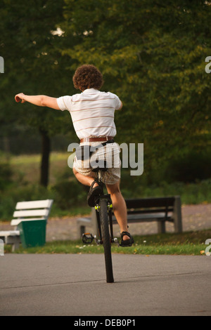 Young man riding a unicycle in the park. Stock Photo