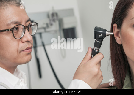 Close-Up of doctor checking the ears of a patient Stock Photo