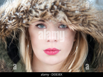 A girl stands in the snow in a fur coat Stock Photo