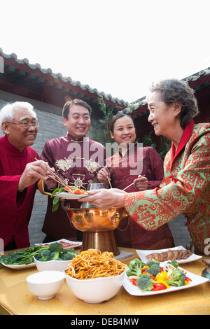 Family enjoying Chinese meal in traditional Chinese clothing Stock Photo