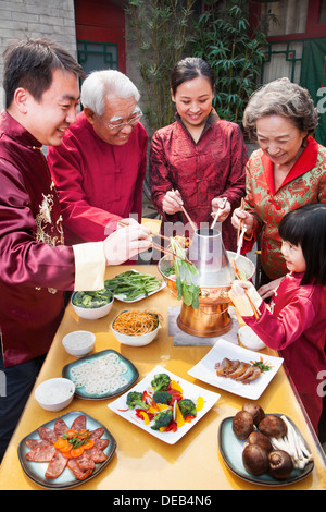 Family enjoying Chinese meal in traditional Chinese clothing Stock Photo