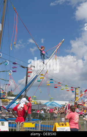 ASHEVILLE, NORTH CAROLINA, USA-SEPTEMBER 13, 2013: Girl having fun bungee jumping as people watch at the NC Mountain State Fair Stock Photo