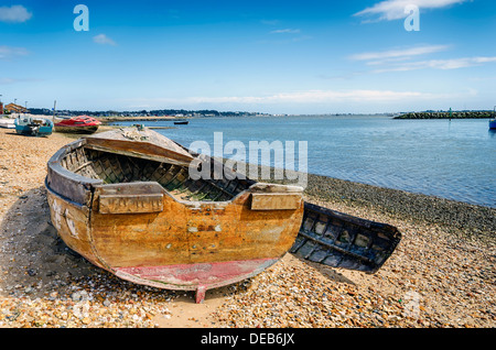 An old wrecked wooden boat on the shore at Poole in Dorset