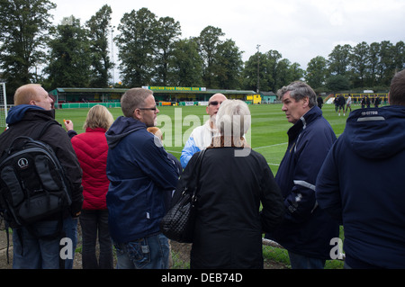 Spectators indulge in conversation prior to kick off at Hitchin Town Football Club in North Hertfordshire, UK Stock Photo