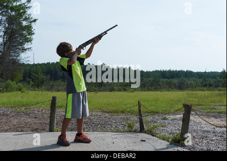 Young boy shooting skeet at the Ocala National Forest Public Shooting Range on State Road 40 in Ocala, Florida USA Stock Photo