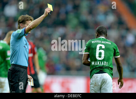 Bremen, Germany. 14th Sep, 2013. Referee Felix Brych shows the yellow card to Werder's Cedric Makiadi during the Bundesliga soccer match Werder Bremen vs Eintracht Frankfurt at the Weser Stadion in Bremen, Germany, 14 September 2013. Photo: CARMEN JASPERSEN/dpa/Alamy Live News Stock Photo