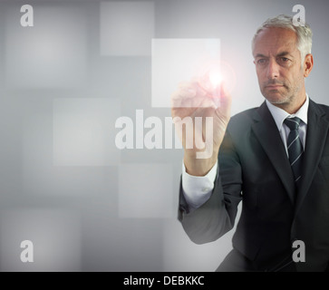 Serious businessman touching empty pane on digital screen Stock Photo