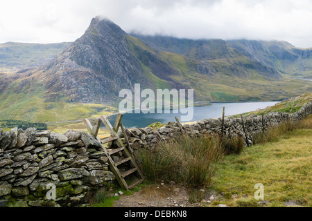 Ladder stile over a drystone wall with view to Mt Tryfan mountain and Llyn Ogwen lake in Ogwen Valley on path to the Carneddau in Snowdonia, Wales, UK Stock Photo