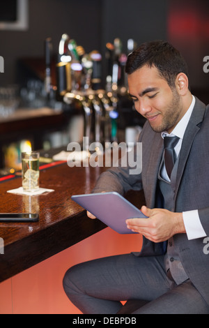 Smiling businessman working on his tablet computer Stock Photo