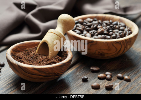 ground coffee and coffee beans in bowls on wooden background Stock Photo