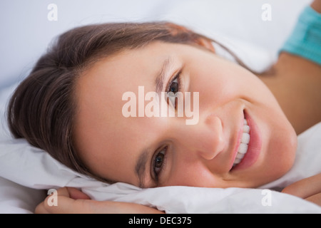 Pretty woman lying in bed looking into the camera Stock Photo