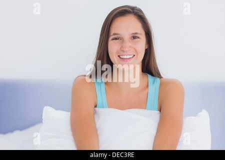 Young woman sitting on bed Stock Photo