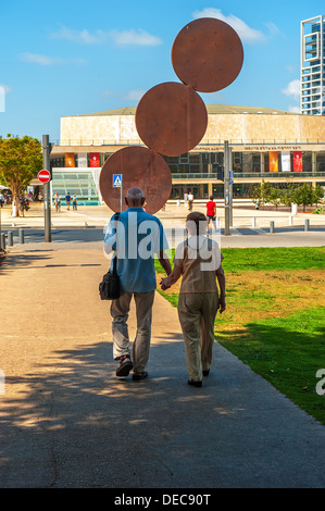 A mature couple walks towards 'Habima Theatre' in Tel Aviv, Israel on Rothschild Boulevard. Stock Photo