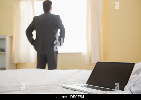 Man standing back in front of the window hands in the pockets Stock Photo