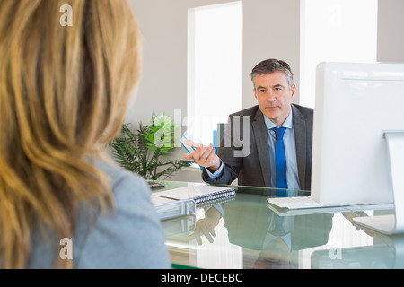 Serious businessman having a discussion with a colleague Stock Photo